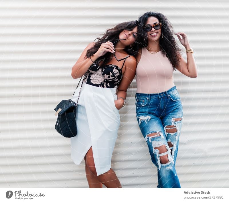 Fröhliche junge Frauen posieren auf der Straße posierend Partnerschaft Freundin Glück Kälte heiter sich[Akk] entspannen ruhen Zusammensein ethnisch Latein