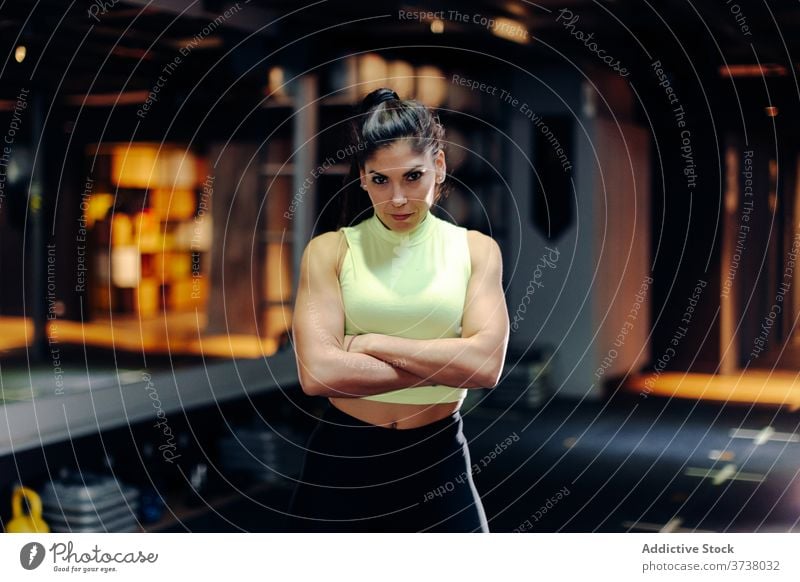 Selbstbewusste fitte Frau im Fitnessstudio stehend sportlich selbstbewusst Bestimmen Sie ernst muskulös stark passen Athlet Sportlerin jung Training Kraft