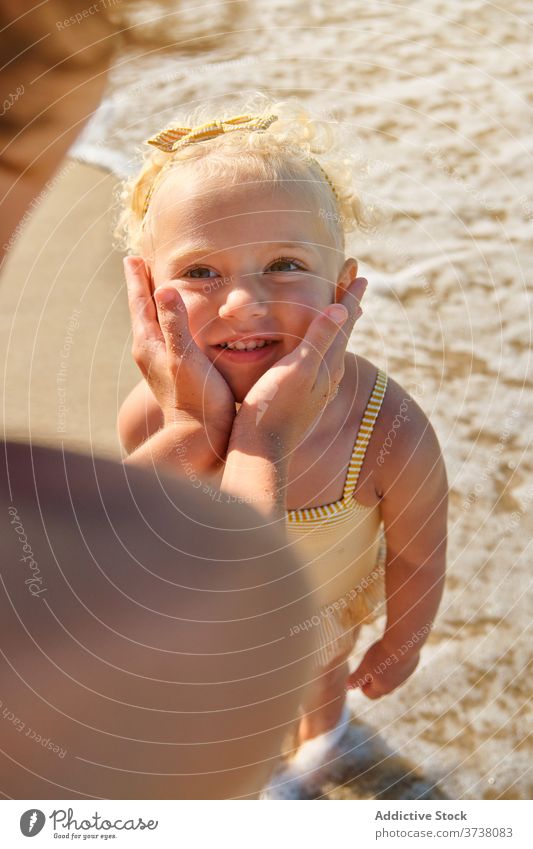 Selektiver Fokus auf das Gesicht eines blonden Mädchens mit fröhlichem Gesichtsausdruck am Strand Umarmen Bräune teilen reden Zusammengehörigkeitsgefühl Bonden