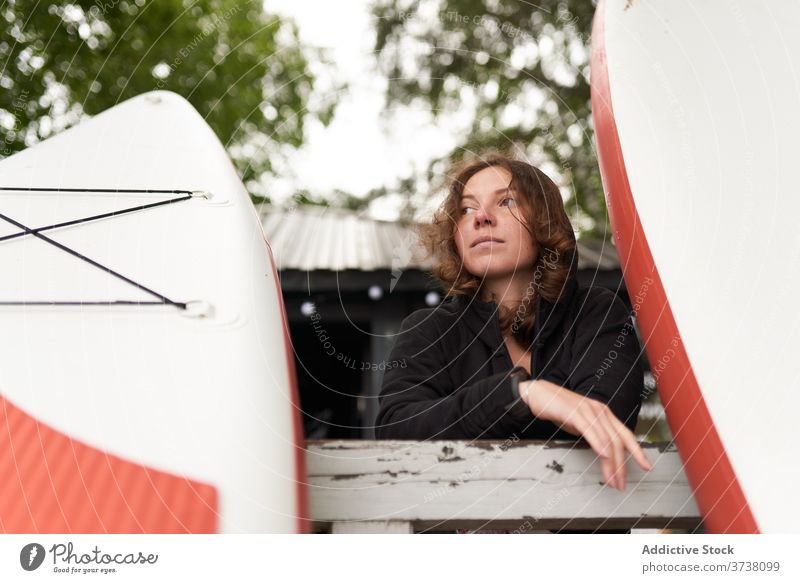 Sportlerin am Ufer mit Paddelbrett Frau sich[Akk] entspannen Surfer Windstille Surfbrett hölzern Stauanlage ruhen Holzplatte Surfen Sommer Athlet Aktivität