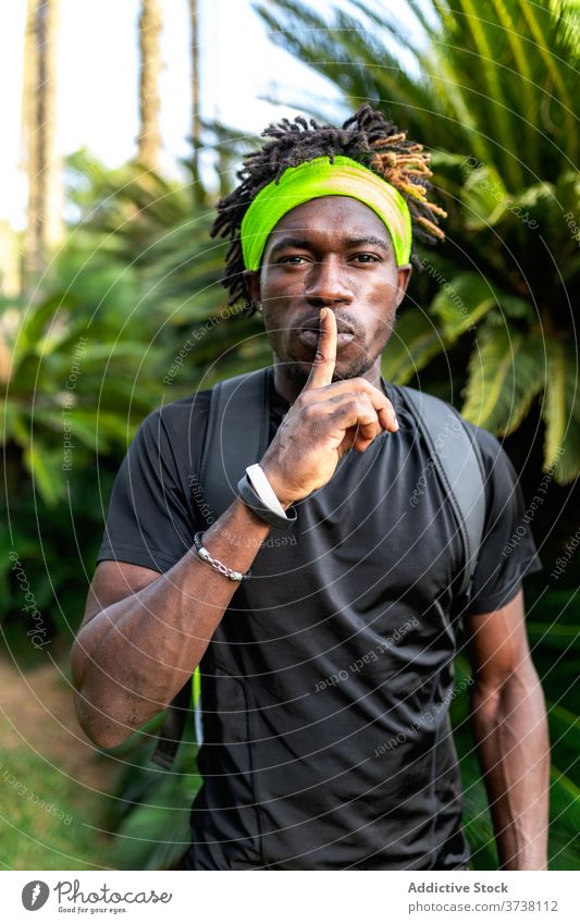 Afroamerikanischer Sportler zeigt Schweigezeichen shh gestikulieren stumm Zeichen Athlet Stil Sportbekleidung sportlich Training jung Afroamerikaner schwarz