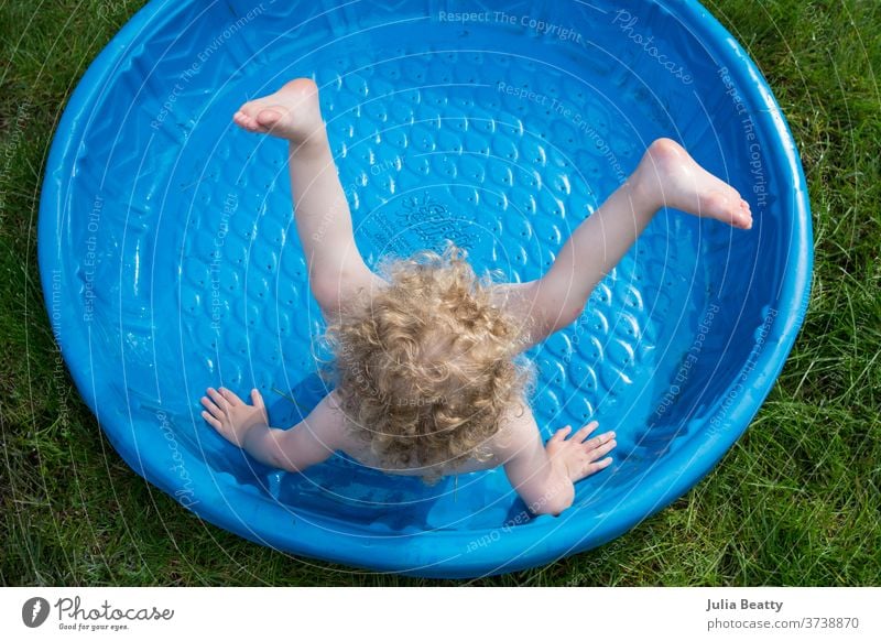 Mädchen im Plastikbecken Pool Kunststoffbecken Kinderbecken Hinterhof Gras Schwimmbad Baden Sommer Spielen blau grün lockig krause Haare blond Wassersport