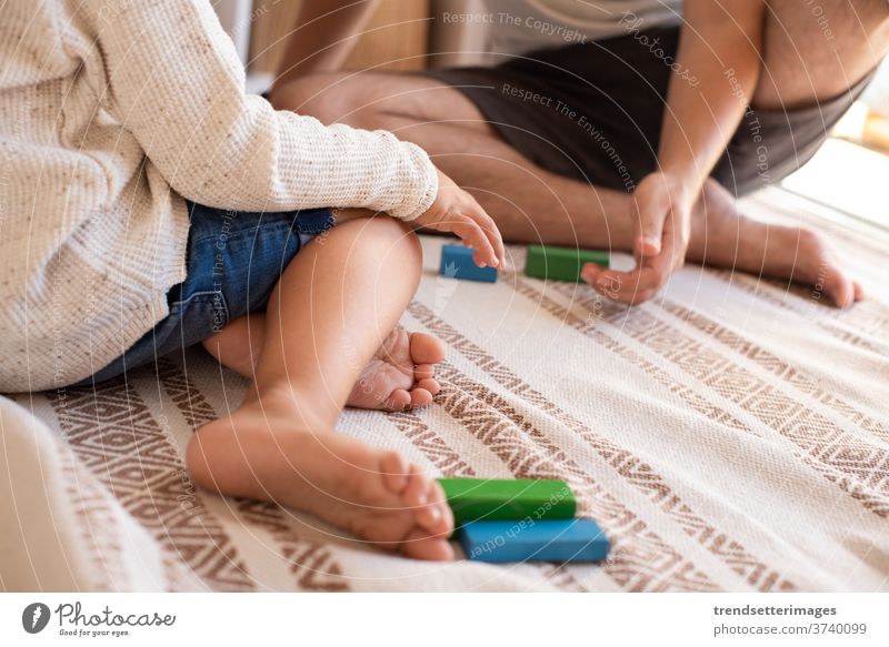 Kind und sein Vater spielen zu Hause mit Holzbausteinen. Heimunterricht. Bleiben Sie zu Hause. Zeit mit der Familie covid-19 sicher Coronavirus zu Hause bleiben