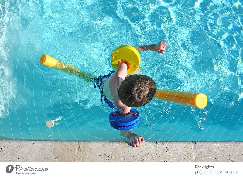 Draufsicht auf einen kleinen Jungen, der mit Schwimmern und Armbändern im Schwimmbad schwimmt Urlaub Feiertag Kind Glück Lifestyle jung Gesundheit Erholung