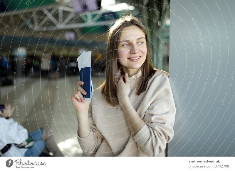 Porträt einer glücklichen jungen Frau mit Reisepass und Bordkarte am Flughafen Mädchen reisen Reisender Passagier Ausflug schön hübsch Abheben Business Lächeln