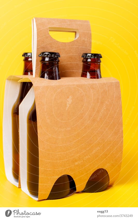 Präsentation einer Packung von vier Bieren mit gelbem Hintergrund bayerisch Belgier Getränk Schnaps Flasche Flaschen Kasten Marke Markenbildung Brauerei