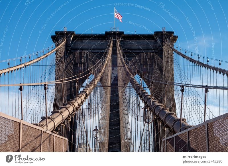 New York City Manhattan zur Brooklyn-Brücke mit Gebrauchsflagge an den oberen Sandaufhängeseilen klassisch traditionell Transport brooklyn brücke new york Stein