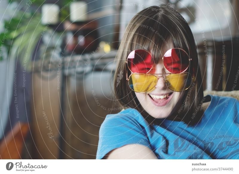 lachende jugendliche mit 2 farbigen sonnenbrillen Jugendliche Teenager lustig Freude Spaß Sonnenbrillen rot gelb Gesicht Fröhlichkeit Glück jung Mädchen Lächeln