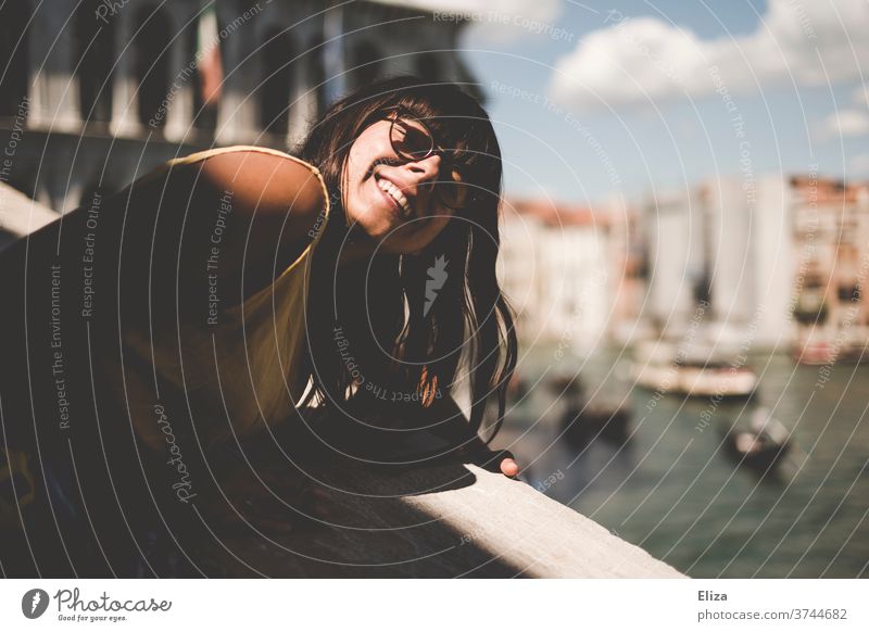 Frau lehnt sich über das Geländer der Rialtobrücke, um ihr Gesicht in die Sonne zu halten Touristin Venedig Lachen Italien Kanal Hafenstadt Freude Brille