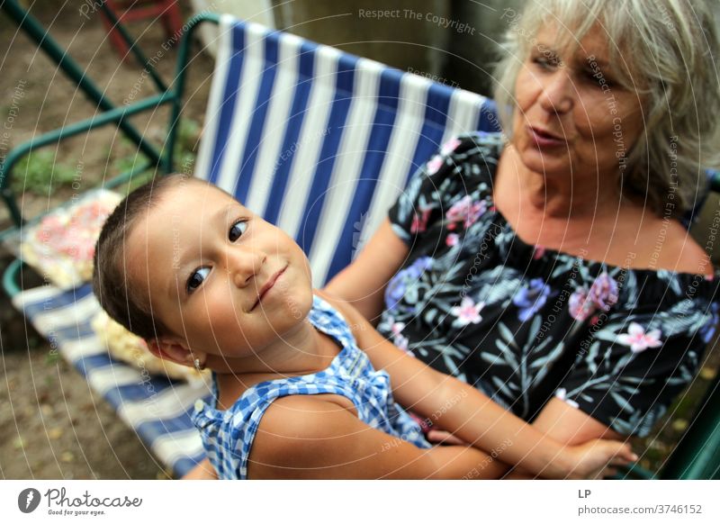 Oma hält lächelndes Kind, das in die Kamera schaut Porträt Liebe Liebkosen Wahrheit Vertrauen Lebensfreude Fröhlichkeit Gefühle Kindheit Paar