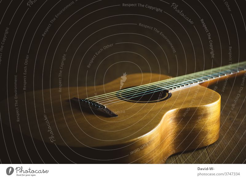 Gitarre im Licht und Schatten Musik Musikinstrument liegen Kultur verbot Auszeit Holz Freizeit & Hobby