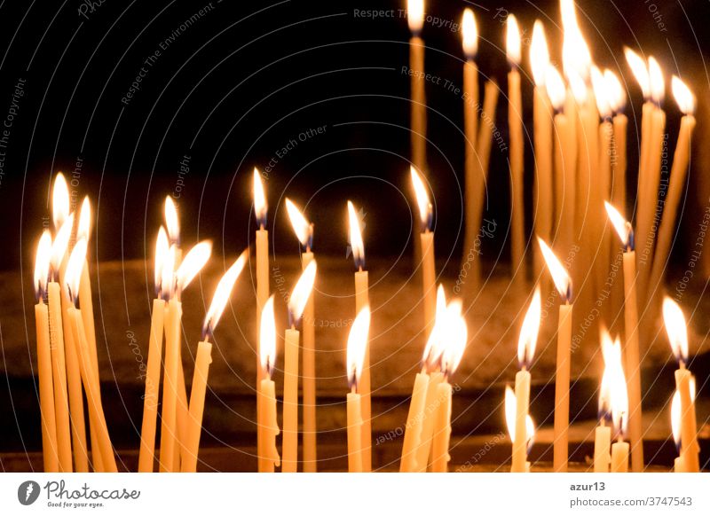 Gruppe von gelben Kerzen in der Kirche für das Auferstehungsgebet des Glaubens. Kerzenschein-Feuerflammen in Kreisreihen sind religiöses Symbol für Frieden, Leben und Seelenstille. Nachruf Hoffnungsopfer gegen die Trauer