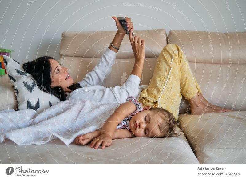 Kleinkind schlafend mit einer Decke mit ihrer Mutter machen ein Selfie neben ihm Erinnerungen Zärtlichkeit Einheit teilen Ruhe träumend neugeboren berühren