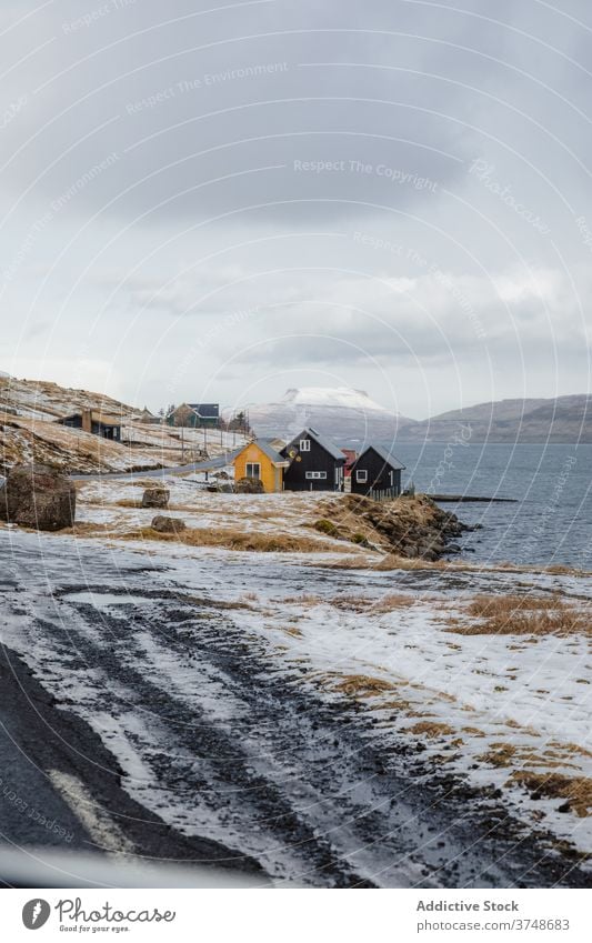 Kleine Siedlung in den Bergen auf den Färöer Inseln Berge u. Gebirge Dorf Wohnsiedlung Winter Schnee Fluss Saison kalt Haus wohnbedingt Färöer-Inseln Landschaft