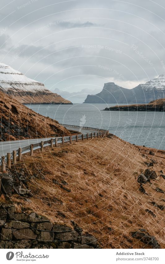 Nasse Bergstraße auf den Färöer Inseln Berge u. Gebirge Straße Winter nass geschlängelt spektakulär Fahrbahn Berghang Fluss kalt Färöer-Inseln Landschaft Felsen
