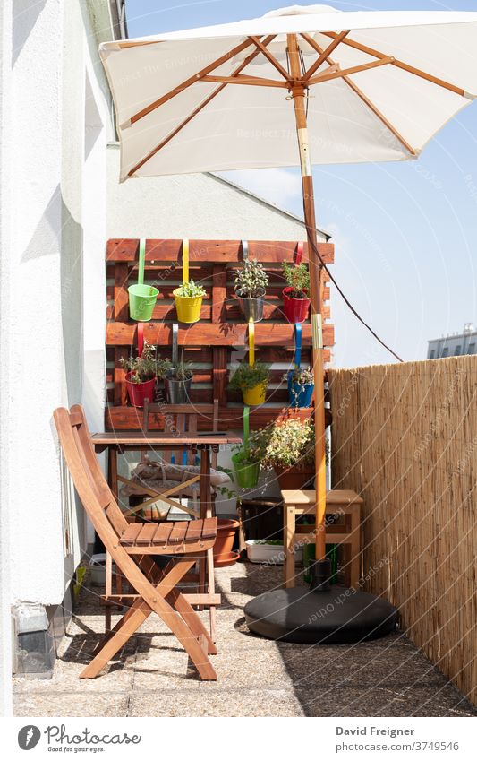 Kleiner Bereich der städtischen Gartenarbeit im Sommer in der Stadt Terrasse Balkon farbenfroh Pflanzen Sonnenschein Stuhl Erholung Topf Töpfe Sonnenschirm