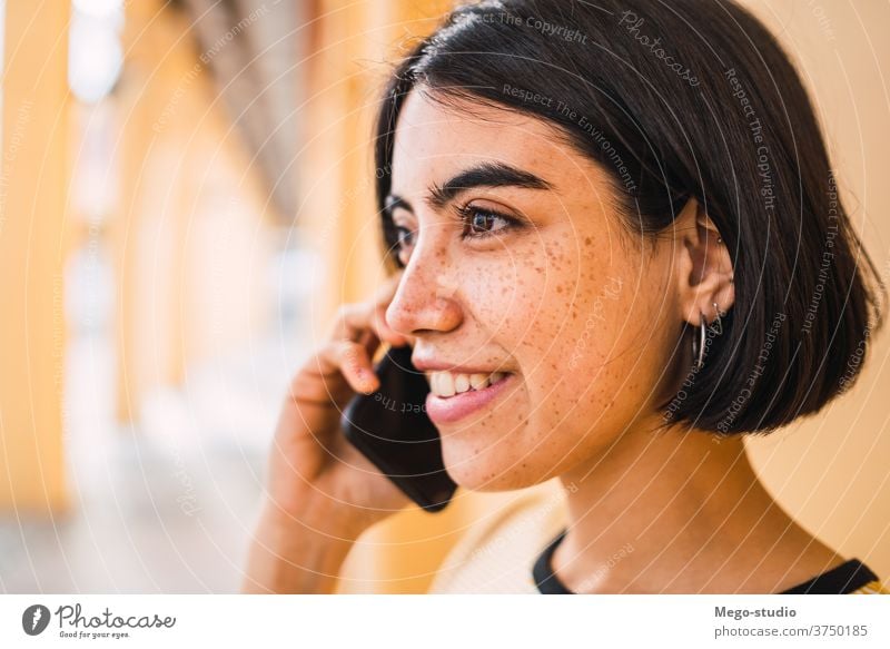 Junge Lateinamerikanerin am Telefon. sprechend Mobile Frau Mädchen im Freien Person Anruf klug Zelle jung brünett Großstadt Smartphone Funktelefon Gespräch