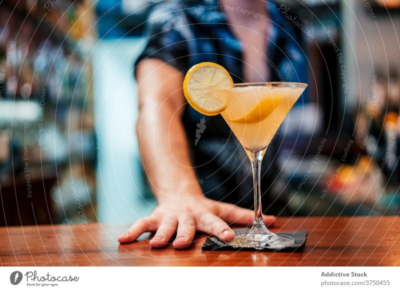 Barkeeper gießt Cocktail in Glas am Tresen Alkohol vorbereiten Mann Barmann eingießen Erfrischung trinken Getränk Abfertigungsschalter Kelch liquide ernst