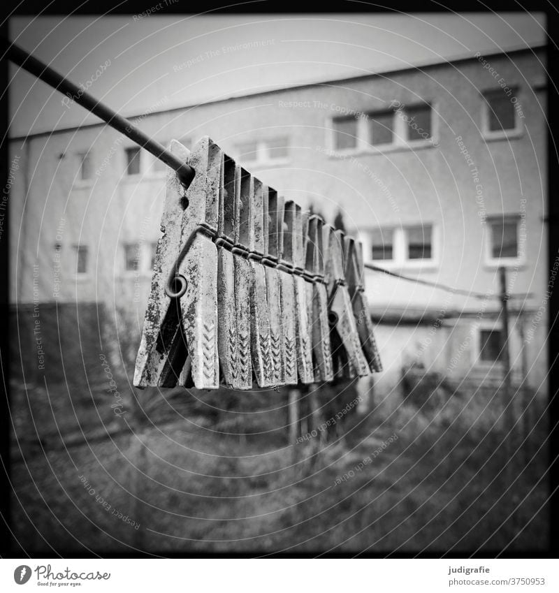 Sich an eine Wäscheleine klammernde Wäscheklammern Klammern Schwarzweißfoto wohnen Häusliches Leben Haus Gebäude Garten marode alt Menschenleer Außenaufnahme