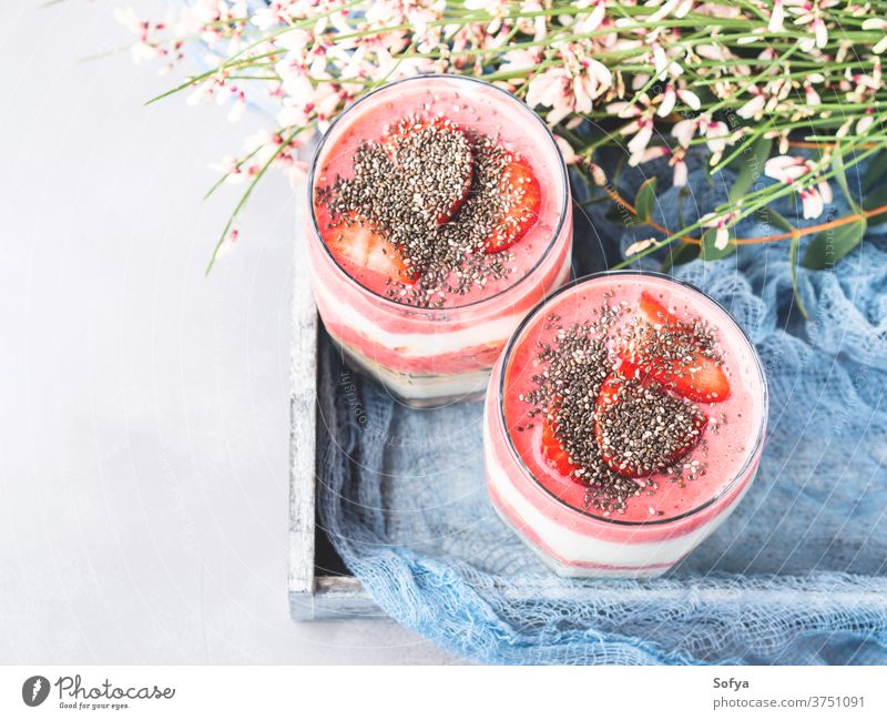 Joghurt-Erdbeer-Fruchtparfait mit Haferflocken Erdbeeren Frühstück gerollt Glas serviert Chia Saatgut Lebensmittel Gesundheit Parfait Ebene gemischt