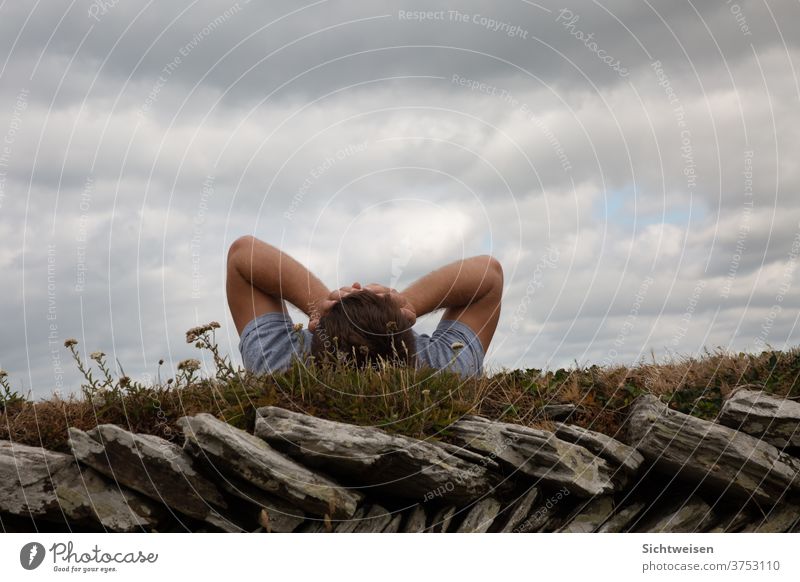 Mann auf dem Rasen mit den Händen vor dem Gesicht Natur Außenaufnahme Umwelt Landschaft Himmel