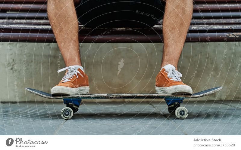Crop Skater sitzen auf Bank in der Stadt urban Skateboard Mann sich[Akk] entspannen Stil Straße cool Generation männlich jung schäbig hölzern Großstadt ruhen