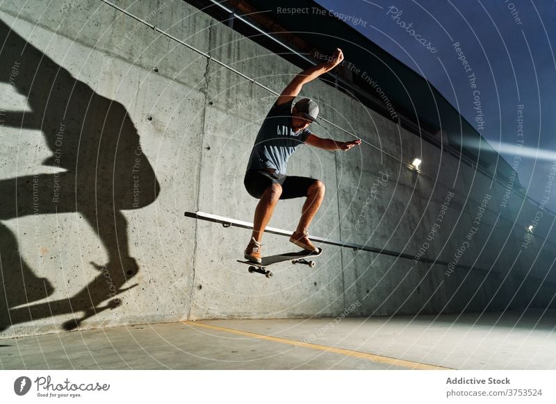 Starker Mann macht Tricks auf Skateboard Skater springen Stunt urban Skateplatz Nacht Fähigkeit männlich Training Schlittschuh Park Sport Talent üben Straße