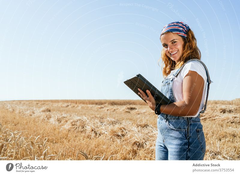 Lächelnde Frau mit Tablet im Feld Landwirt Weizen Tablette Browsen benutzend Ackerbau Landschaft ländlich Apparatur Gerät Sommer Natur Wiese Schonung Ackerland