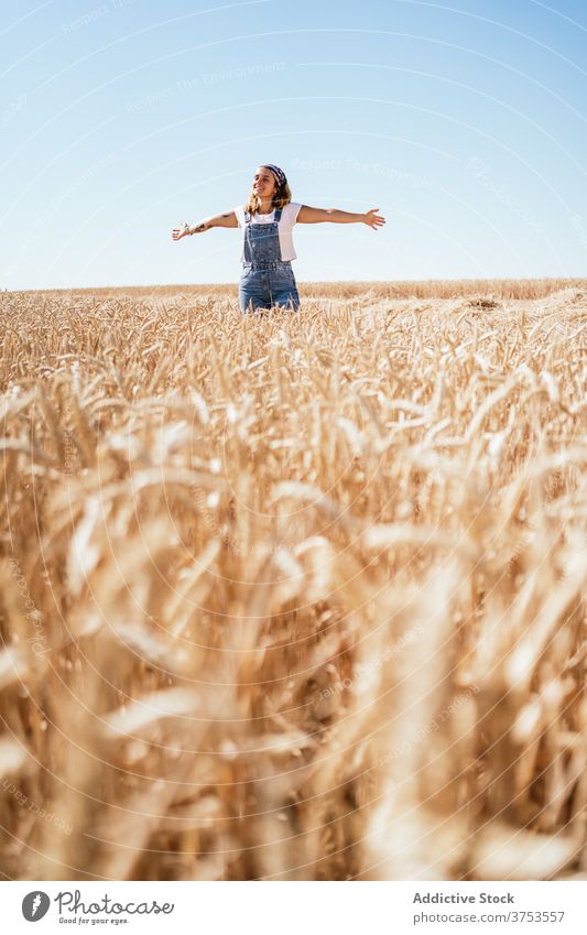 Sorglose Frau im Feld im Sommer sorgenfrei Landschaft Freiheit genießen Freude Weizen golden Natur Jeansstoff gesamt heiter Urlaub Wiese Himmel positiv