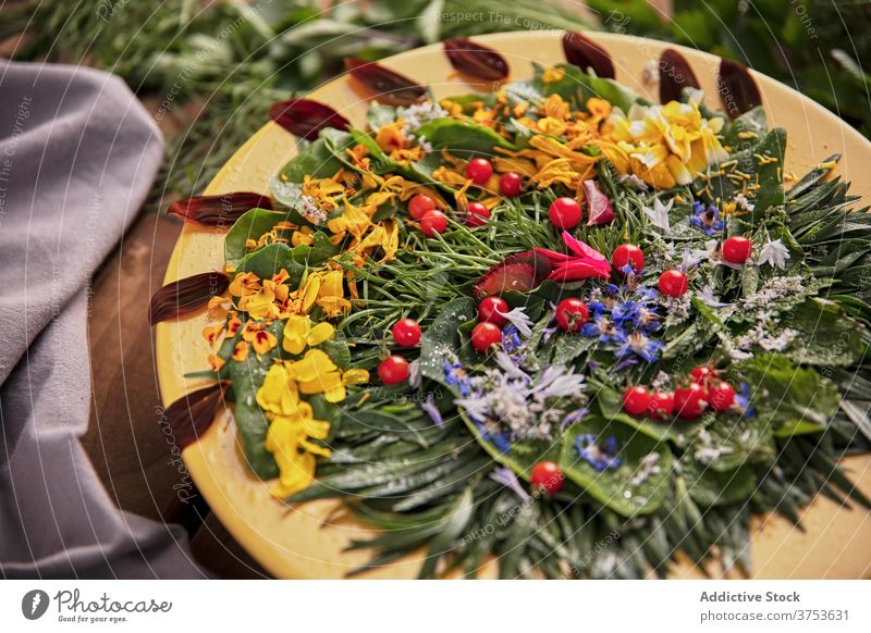 Leckeres Grünzeug mit Blütenblättern auf Teller Blume Zusammensetzung Kraut Ordnung Blütenblatt grün hölzern Tisch reif frisch Natur Sommer Blütezeit Flora