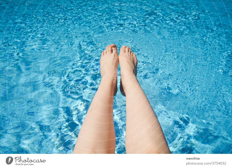 Weiße Frau mit Beinen gegen ein türkisfarbenes Schwimmbeckenwasser Sommer Pool Fuß Feiertage Wasser frisch Frische weiß Kaukasier Sonne sonnig behüten