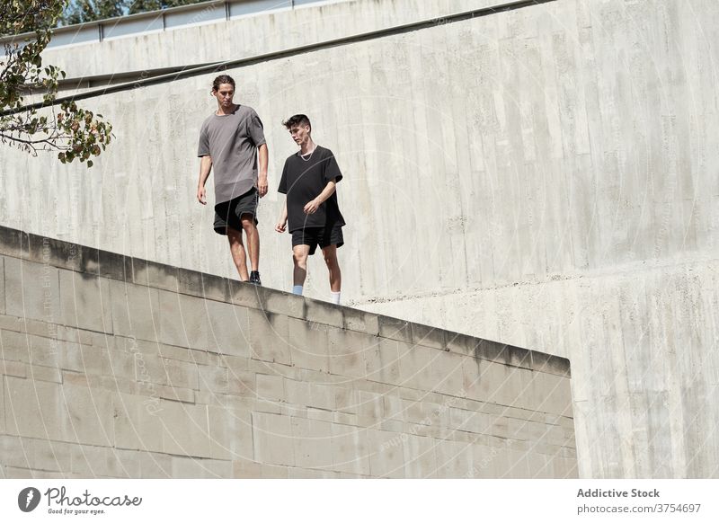 Junge Männer stehen auf dem Dach eines Gebäudes in der Stadt Le Parkour Trick vorbereiten Großstadt Freestyle urban jung Fähigkeit Beton Borte extrem Aktivität