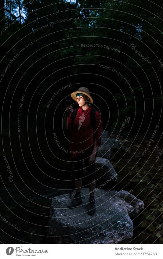 Reisende Frau navigiert mit Smartphone im dunklen Wald navigieren Reisender Nacht Landkarte digital Navigator benutzend Route Wälder Felsen Tourist Suche
