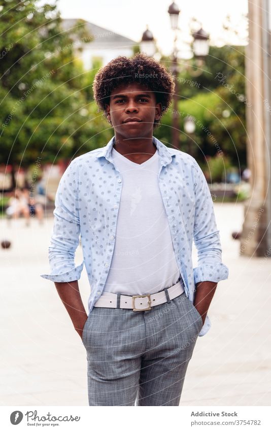 Nachdenklicher ethnischer Mann auf einer Stadtstraße Stil Straße Großstadt trendy Afro-Look Frisur Wochenende genießen männlich schwarz Afroamerikaner jung