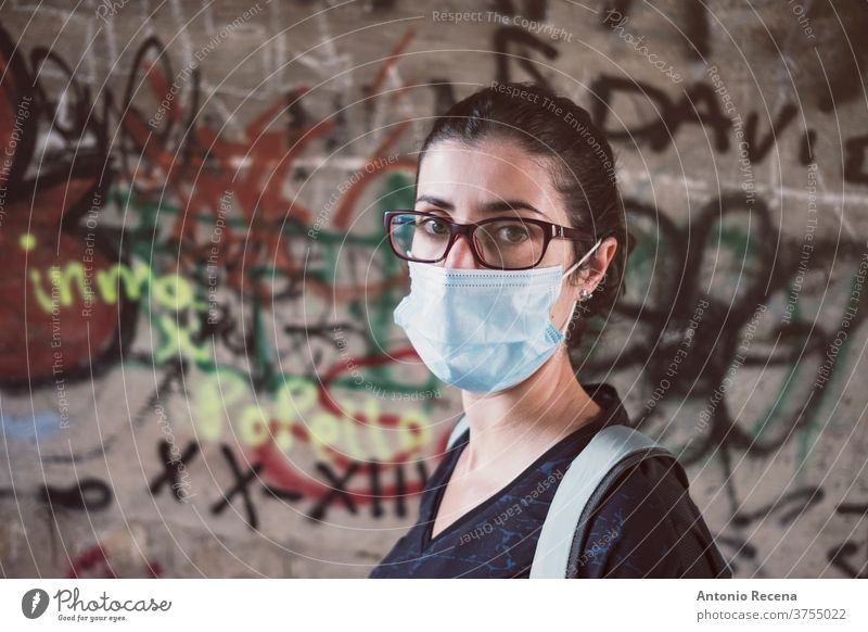 Frau im Kamerablick mit Gesichtsmaske auf Stadtfoto Frauen Bund 19 Graffiti Person Menschen 30s 30-34 Jahre 30-39 Jahre Rucksack laufen wandern Brille Pandemie