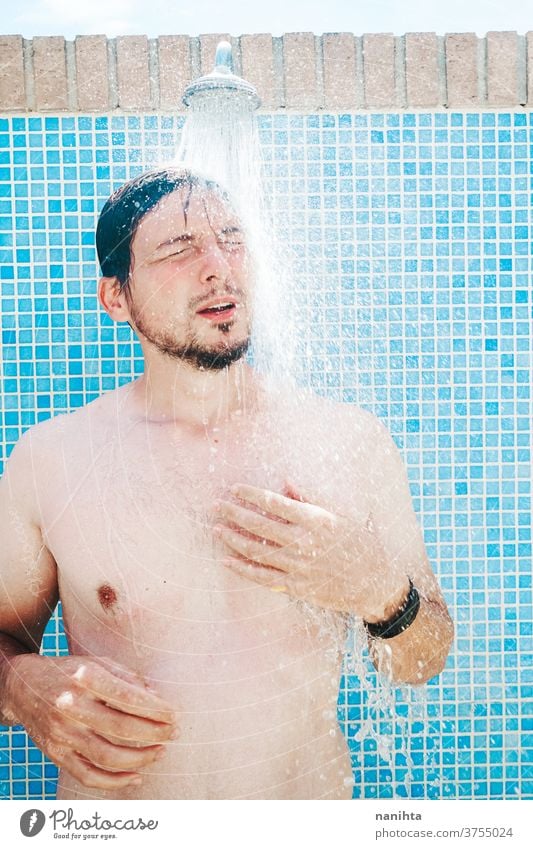 Junger Mann duscht vor dem Schwimmbad Dusche Sommer attraktiv weiß Kaukasier Bräune wirklich echte Menschen echter Mann offen frisch Frische cool Kühle Körper