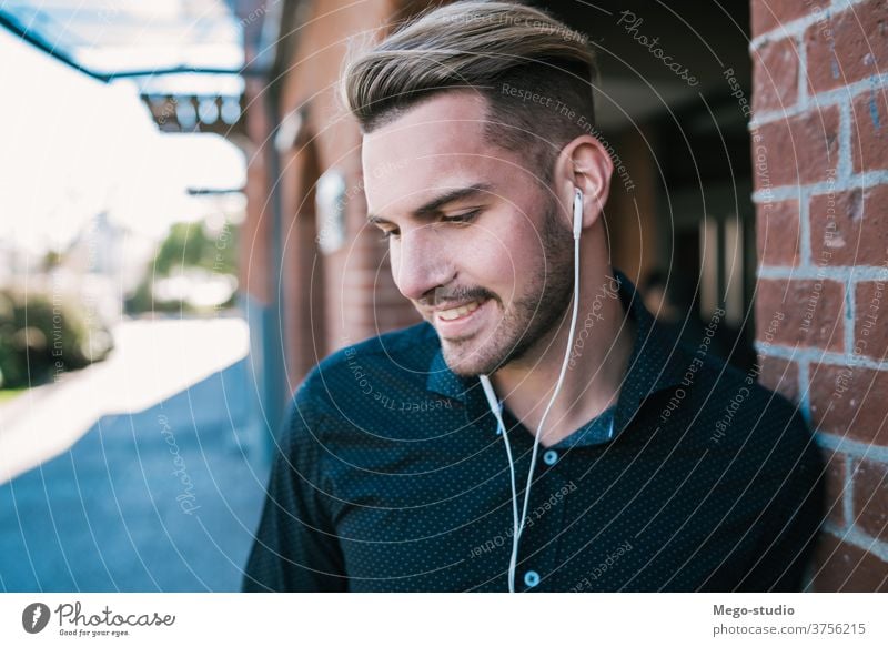 Mann, der mit Kopfhörern Musik hört. Person jung zuhören Menschen Erwachsener Apparatur im Freien Technik & Technologie Lifestyle männlich lässig allein Klang