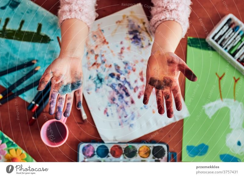 Kleines Mädchen im Vorschulalter mit bemalten bunten Händen Kind Malerei Farbstoff Bildung farbenfroh Kunst heimwärts Papier Kindheit Vorschule Schaffung