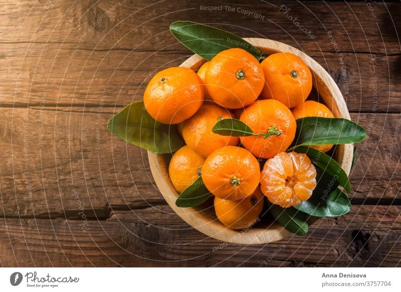 Köstliche und schöne Mini-Mandarinen orange Clementine Zitrusfrüchte Nahaufnahme reif grün Gesundheit frisch süß Frucht organisch saftig Natur weiß hölzern