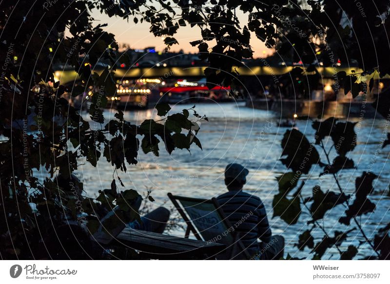 Am Ufer eines großen Flusses kann man mitten in der Stadt einen romantischen Sonnenuntergang erleben Strandbar Liegestühle Abend Lichter Großstadt Wien