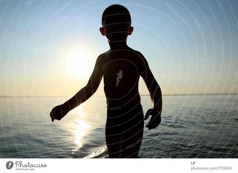 Kontrastieren der Silhouette eines Kindes mit Meer und Himmel Schwache Tiefenschärfe Schatten Licht Tag Außenaufnahme Aktion Körper Junge Mensch Versuch Mut