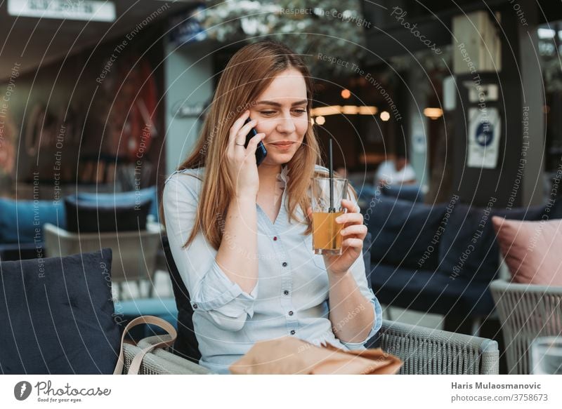 Junge Frau lächelt mit Handy in der Hand in der Mittagspause Erwachsener attraktiv schön Business Geschäftsfrau Café Kaffee Kaffeehaus Mitteilung Gesichtsmaske