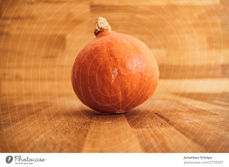 Hokkaidokürbis auf Holztisch zum Erntedank Erntedankfest Gemüse Halloween Herbst Hokaido Hokaidokürbis Holzhintergrund Kürbis Nahrung Saison Selbstversorger