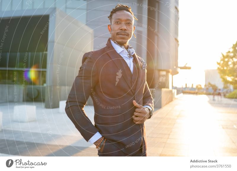 Selbstbewusster Geschäftsmann im stilvollen Anzug in der Stadt Großstadt Unternehmer Bestimmen Sie ernst Sonnenlicht Stadtzentrum Metropole männlich ethnisch