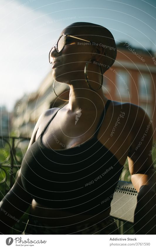 Selbstbewusste stilvolle ethnische Frau in der Stadt kahl Vorschein Stil trendy Café Sommer Terrasse selbstbewusst außergewöhnlich schwarz Afroamerikaner Frisur