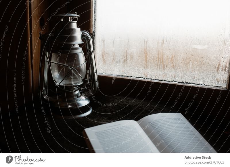 Vintage Kerosinlampe und Buch auf der Fensterbank Erdöl Laterne Lampe gemütlich Fenstersims Atmosphäre hölzern altehrwürdig retro Raum Komfort ruhig Nebel Haus