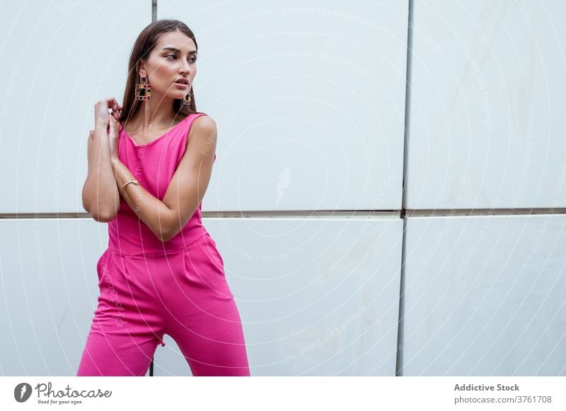 Modisches weibliches Modell in rosa Overall Frau Stil gesamt farbenfroh trendy elegant Glamour Accessoire Ohrringe traumhaft urban modern schlank schick