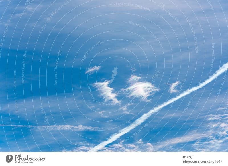 Wolkenfetzen mit bunten Lichtreflexionen vor blauem Himmel und Kondensstreifen von Flugzeugen Freiheit Hoffnung Einsamkeit Kreativität einzigartig Farbfoto