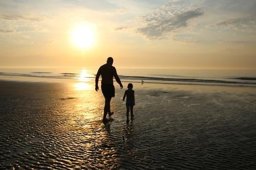 Vater und Sonne beim Spaziergang am Strand bei Sonnenuntergang Eltern Sonnenstrahlen Sonnenlicht Strukturen & Formen Muster Schutz Lebensfreude Fröhlichkeit