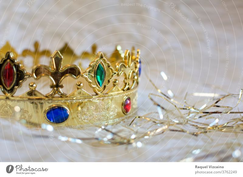 Königliche Goldkrone, mit farbigen Edelsteinen und Diamanten, auf weißem Hintergrund mit umlaufenden goldenen Bändern. Weihnachten Dekoration & Verzierung